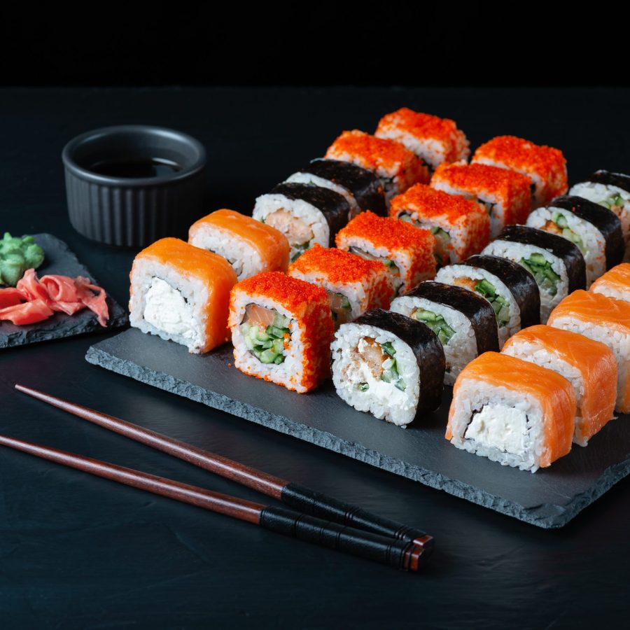 Different sushi rolls on a black background.